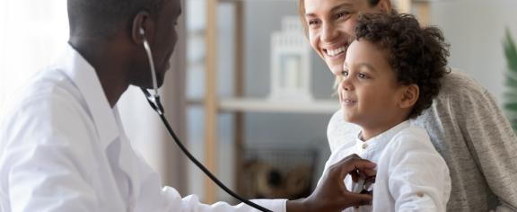 A pediatrician listens to a young patient's heartbeat with a stethoscope