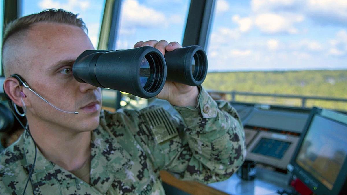 Soldier looking through binoculars.