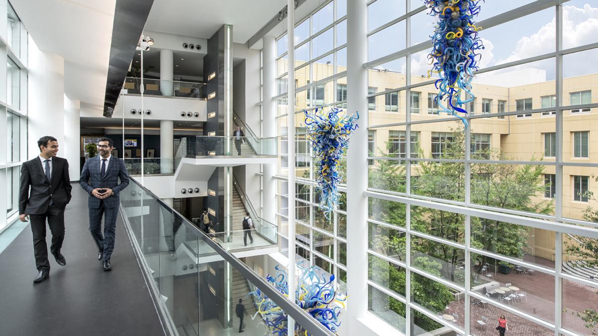 Students in business attire walking inside of Scheller College of Business.