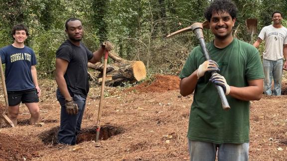 Benjamin Manoj (front) and other Yellow Jackets Against Poverty members dig holes for the foundation of a new homeless shelter.