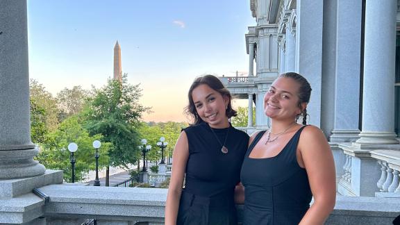 Students in the GTDC: Pathways to Policy program pose for a photo with the Washington Monument in the backgroumd.
