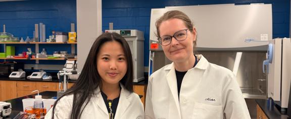 Grace Tang (Left) and Alison Onstine (Right) holding bacteria plates that spell "BIOL 4590" (Credit: Tang and Onstine)