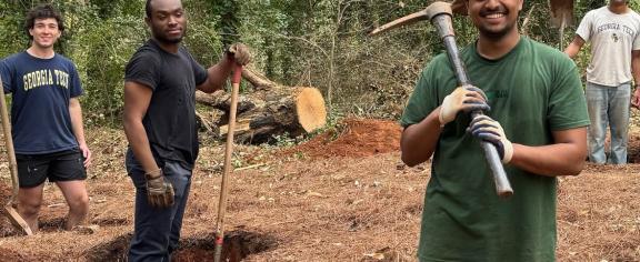 Benjamin Manoj (front) and other Yellow Jackets Against Poverty members dig holes for the foundation of a new homeless shelter.