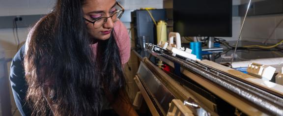 Former Matsumoto Group member Krishma Singal operates a knitting machine used to create fabric samples for a previous study. Singal recently graduated from Georgia Tech with her Ph.D. (Photo Credit: Allison Carter)