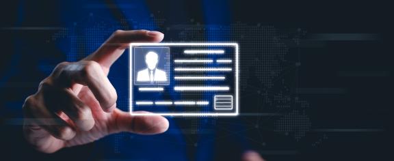 A hand holds up a digital identification card. The card has the silhouette of a man wearing a suit and tie. 