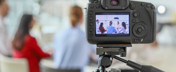 camera filming people at a table