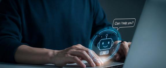 A person at a computer. A little digital robot is hovering near his fingers.