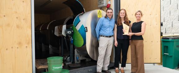 From left to right, Steve Place, campus sustainability program manager; Abby Bower, program and portfolio manager, and Jennifer Chirico, associate vice president of the Office of Sustainability are pictured with Georgia Tech's Sustainability Innovation Award in front of the campus's in-vessel composter.