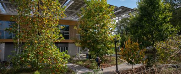 Image of micromobility user in the EcoCommons performance landscape adjacent to The Kendeda Building for Innovative Sustainable Design