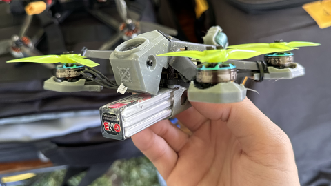 A handing holding a small racing drone
