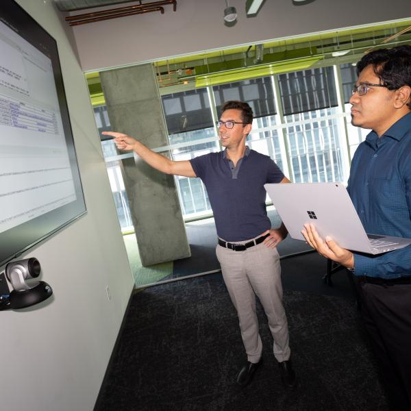 Brendan Saltaformaggio, left, and Amit Sikder are working on a $10 million DARPA project to unpack legacy software systems, incorporate updates, and redeploy them in weeks or months rather than years. (Photo: Candler Hobbs)
