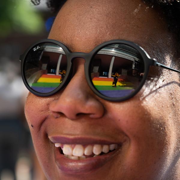 Buzz is reflected in Christen Steele’s glasses as she admires the Progress Pride Staircase at its grand opening in 2021. Photo by Allison Carter