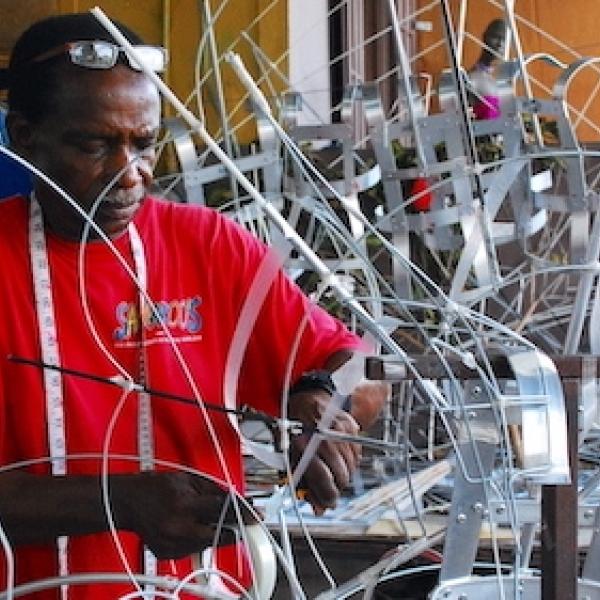 An artisan from Trinidad and Tobago uses traditional skills to build an intricate wire frame that will support a large, elaborate Carnival costume. 