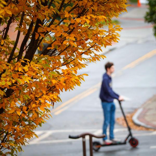 Student Rides a Scooter on Campus
