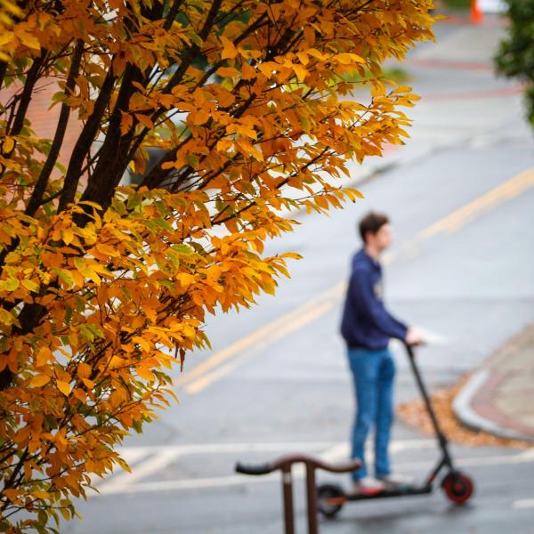 Student Rides a Scooter on Campus